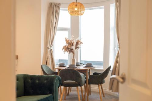 a dining room with a table and chairs and a window at Apartment 3, King's Court in Scarborough