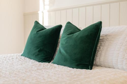 two green pillows sitting on top of a bed at Apartment 3, King's Court in Scarborough