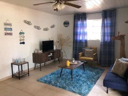 a living room with a blue couch and a tv at Local Home Aruba in Catiri