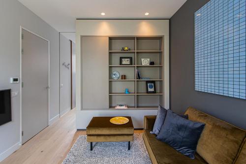 a living room with a couch and a table at OHotellMe City Apartments Rotterdam in Rotterdam