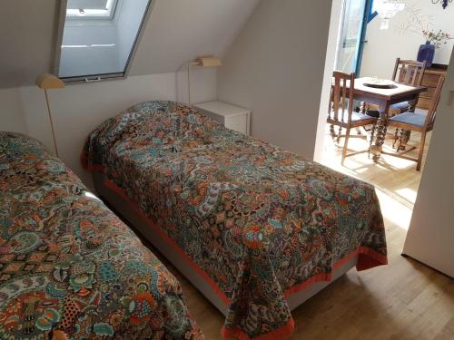 a bedroom with two beds and a table with a chair at Wohnung-D in Glowe