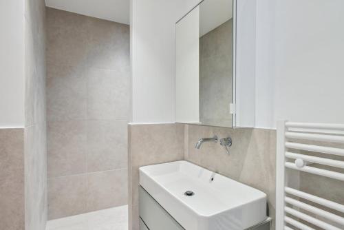 une salle de bain avec un lavabo blanc et un miroir dans l'établissement 311 Suite Elisa - Superbe Appartement à Paris., à Paris