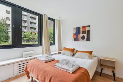 une chambre avec un lit et deux fenêtres dans l'établissement 311 Suite Elisa - Superbe Appartement à Paris., à Paris