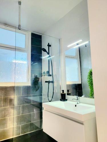 une salle de bain blanche avec une douche et un lavabo dans l'établissement Chambre tout confort, à Tarbes