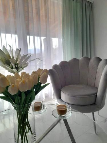 salon z krzesłem i stołem z kwiatami w obiekcie Merter Apartments w mieście Kawadarci