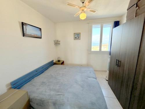 une chambre avec un grand lit avec un ventilateur de plafond dans l'établissement Agréable appartement pour 4 personnes avec piscine collective 4MAR207, au Barcarès