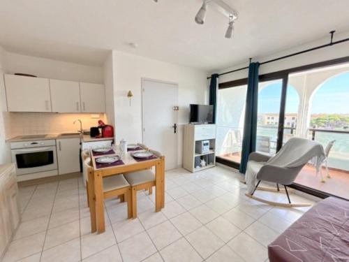 - une cuisine avec un bureau et une table dans une chambre dans l'établissement Agréable appartement pour 4 personnes avec piscine collective 4MAR207, au Barcarès