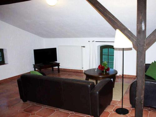 a living room with a couch and a television at Ferienwohnungen im Bauernhaus _ Ob in Papendorf