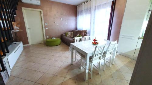 a living room with a table and chairs and a couch at Apartment A&D Home Imola in Imola