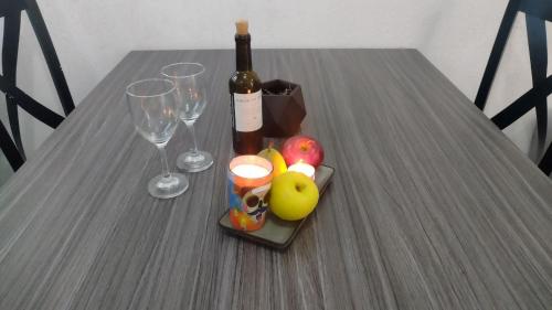 a table with a bottle of wine and two wine glasses at Turquoise Comfort Haven in Cancún