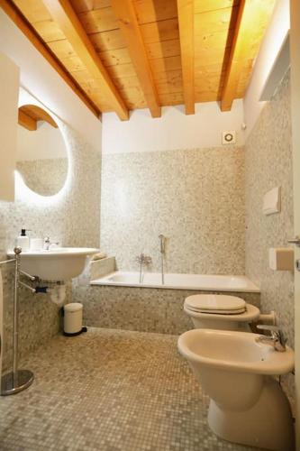 a bathroom with a toilet and a sink and a tub at Dimora Leon Bianco - eleganza e centralità in Padova