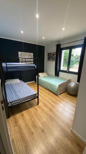 Cette chambre comprend 2 lits superposés et du parquet. dans l'établissement Villa avec piscine entre terre et mer, à Saint-Hilaire-de-Brethmas