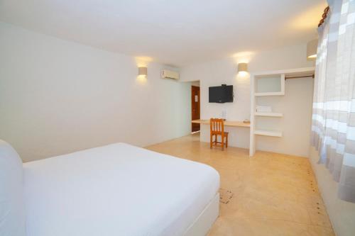 a bedroom with a white bed and a desk at HOTEL BIULÚ in Santa Cruz Huatulco