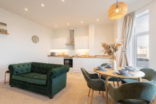 a living room with a green couch and a table at Apartment 4, King's Court in Scarborough