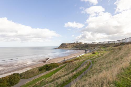 a view of a beach with people walking on the sand at Apartment 4, King's Court in Scarborough