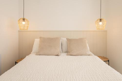 a white bed with two pillows and two lights at Apartment 4, King's Court in Scarborough