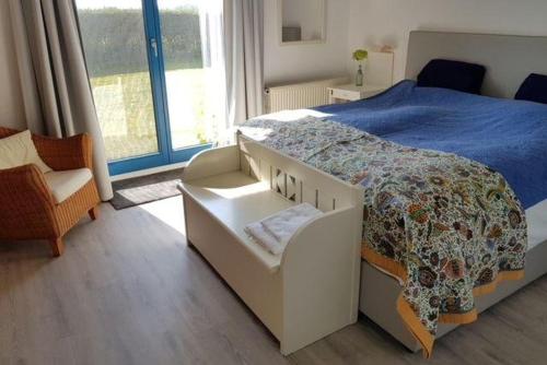 a bedroom with a bed and a chair and a window at Wohnung-A in Glowe