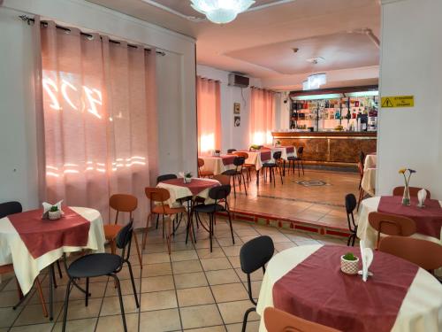 a restaurant with tables and chairs and a bar at Hotel Martini in Naples