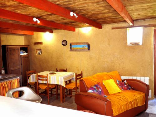 a living room with a table and a couch at Les Gîtes du Couvent Alternatif in Camlez