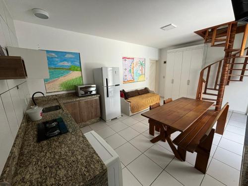 een keuken en eetkamer met een tafel en een koelkast bij Casa de Hóspedes com Piscina em Porto Belo in Porto Belo
