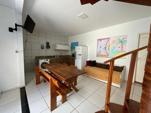 een keuken met een houten tafel en een koelkast bij Casa de Hóspedes com Piscina em Porto Belo in Porto Belo