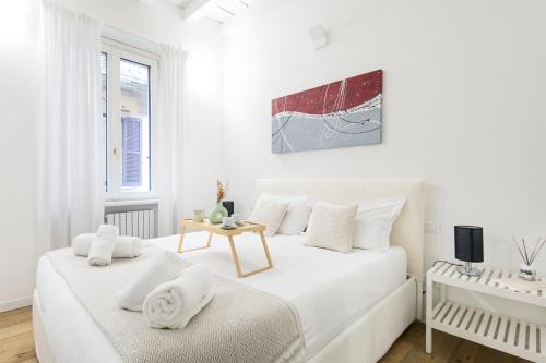 biała sypialnia z 2 łóżkami i stołem w obiekcie Amazing, new & fully furnished studio in Duomo w Mediolanie