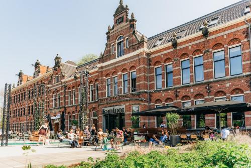 a group of people sitting outside of a brick building at Conscious Hotel Westerpark in Amsterdam