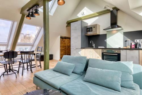 un salon avec un canapé bleu et une cuisine dans l'établissement Armand superbe F4 centre Rouen vue incroyable !, à Rouen