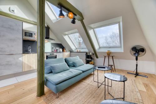un salon avec un canapé bleu et une cuisine dans l'établissement Armand superbe F4 centre Rouen vue incroyable !, à Rouen