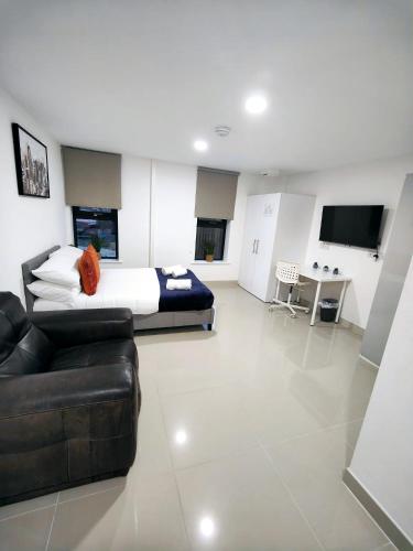 a large bedroom with a bed and a couch at Luxurious 3 bed Ensuites & kitchenettes Nr LGI Hospital & Uni - Free 5G WIFI & Netflix Short Stays - Contractors Free Parking in Leeds
