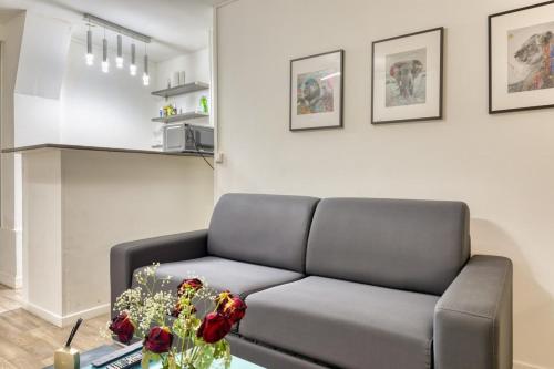 un salon avec un canapé et une table dans l'établissement Le Nicholson votre studio proche cathédrale !, à Rouen