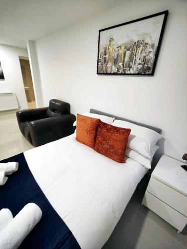 a bedroom with a white bed and a chair at Luxurious 3 bed Ensuites & kitchenettes Nr LGI Hospital & Uni - Free 5G WIFI & Netflix Short Stays - Contractors Free Parking in Leeds