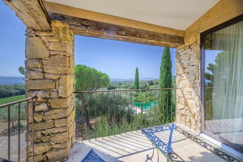 Cette chambre dispose d'un balcon avec vue sur la piscine. dans l'établissement Le Domaine CLEMENT SAINTE-VICTOIRE, à Puyloubier