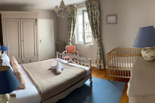 - une chambre pour enfants avec un lit bébé et une chaise haute dans l'établissement Appartement spacieux avec grande terrasse, à Cabourg