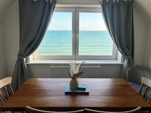 a table with a vase on it in front of a window at Dream Beach in Weymouth