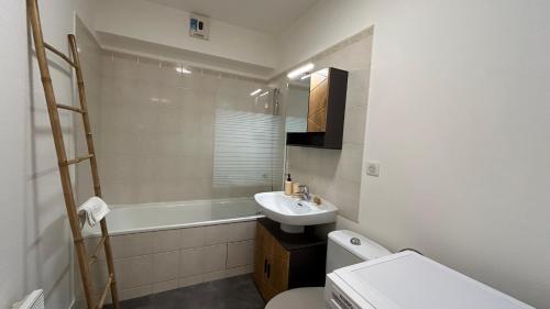 a bathroom with a sink and a toilet and a tub at Lafayette - Guyancourt in Guyancourt