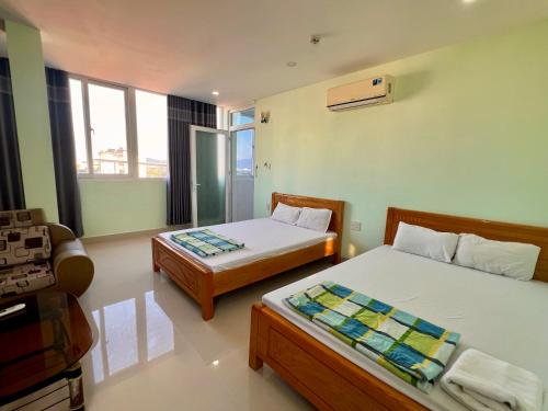 a room with two beds and a couch in it at HT Phuong Thao Boutique in Nha Trang