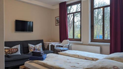 a living room with two beds and a couch at Pension Weseraue in Holzminden