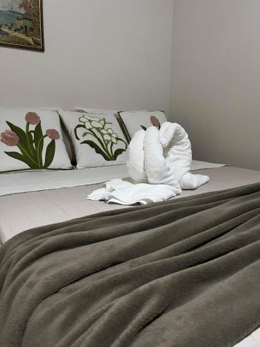 a bed with a towel animal sitting on top of it at Pousada Luar de Caraíva in Caraíva