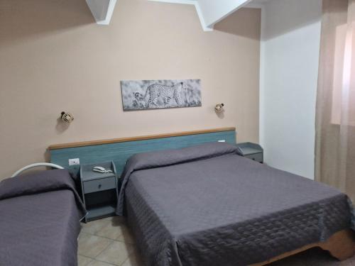 a bedroom with two beds and a painting on the wall at Hotel Martini in Naples