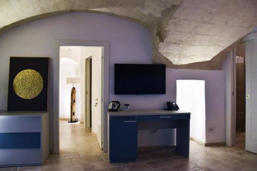a room with a desk and a tv on a wall at 5 Elementi Sassi Matera in Matera