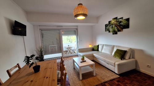 a living room with a couch and a table at Apartamentos Jardim do Morro in Vila Nova de Gaia