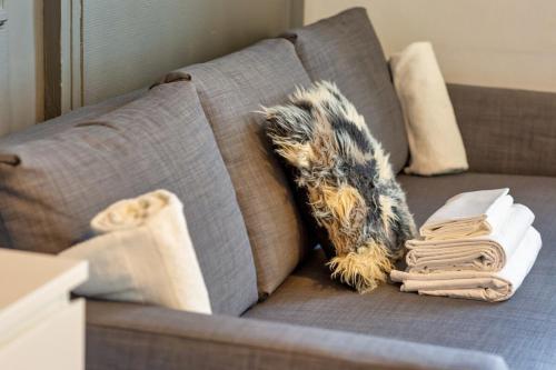 - un canapé avec des oreillers et une couverture dans l'établissement Le Black Angel votre studio au cœur de Rouen !, à Rouen