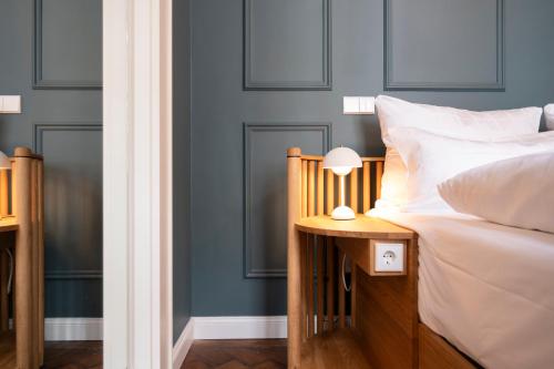 a bedroom with blue walls and a bed with a lamp at Hotel Uhland in Munich
