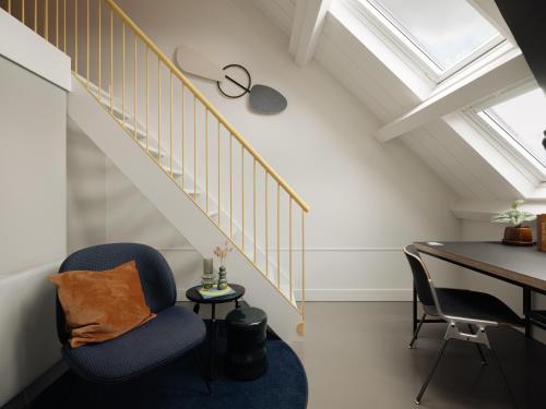 a room with a desk and a chair and a staircase at Conscious Hotel Westerpark in Amsterdam