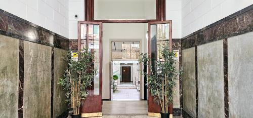 a hallway with potted plants in a building at Il Magnifico Superior Rooms 400m from Tiburtina Railway Station and 290m from Metro in Rome