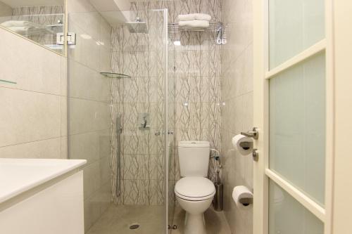 a bathroom with a toilet and a glass shower at Idelson Hotel in Tel Aviv