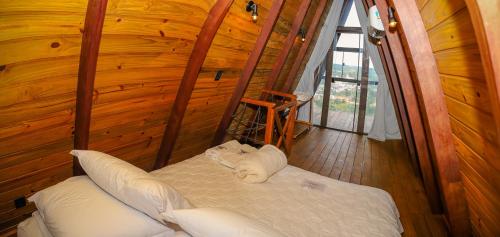a room with a bed in a wooden cabin at Chalés Alta Vista in Bananeiras
