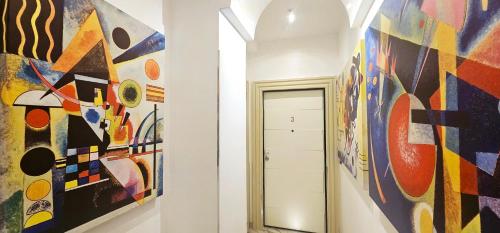 a hallway with colorful paintings on the walls at Il Magnifico Superior Rooms 400m from Tiburtina Railway Station and 290m from Metro in Rome