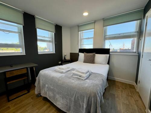 a bedroom with a bed with two towels on it at PS APARTMENTS in Southampton